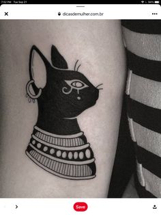 a black and white cat tattoo on the left arm, with an ornament around it