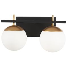 two white and gold balls are hanging from a black wall mounted light fixture, with one bulb turned on