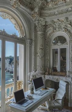 a laptop computer sitting on top of a desk in front of a window overlooking the ocean