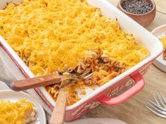 a casserole dish with meat and cheese in it on a table next to other dishes