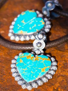 Beautiful custom cut turquoise heart pendants, surrounded with our sterling shot bead Conchos. Shot beads are solid silver and are very tedious and time consuming to produce. I love these with our braided kangaroo leather necklaces or Navajo Canyon 60 inch Pearls! Brilliant blue and green Kingman turquoise in pillow cut - what a fun pendant! Fluted shot bead top, we can do custom sizes, shown here in Mas Grande. This pendant finished about 2 by 2 inches. Hearts can take a little time to cut, cus Artisan Heart Pendant Jewelry, Artisan Jewelry With Heart Beads, Western Style Engraved Blue Jewelry, Western Style Hand-tooled Jewelry Gift, Southwestern Style Hand Tooled Necklace As Gift, Handmade Western Style Jewelry Gift, Handmade Western Jewelry For Gifts, Adjustable Turquoise Heart Pendant Jewelry, Handmade Western Style Jewelry For Gifts