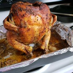 a roasted chicken sitting on top of tin foil