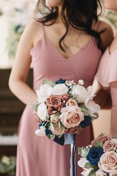 two bridesmaids in pink dresses hold their bouquets