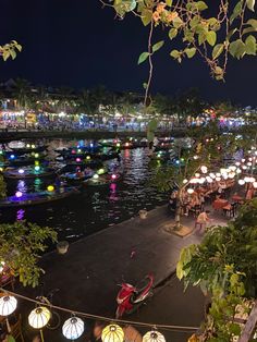 an outdoor restaurant with many lights on the water