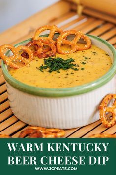 a close up of a bowl of food with pretzels on the side and text that reads warm kentucky beer cheese dip