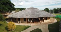 an aerial view of a building with a thatched roof and trees in the background