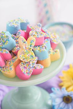 a cake plate topped with colorfully decorated cookies