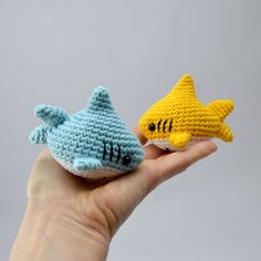 two small crocheted toy animals in the palm of someone's hand