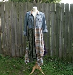 a mannequin is standing in the grass next to a fence with a denim jacket on it