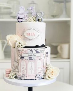 a three tiered cake decorated with pink and white flowers on top of a table