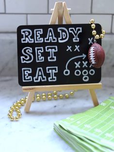 a sign with a football hanging from it's side on top of a table