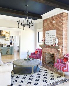 a living room filled with furniture and a fire place next to a brick fireplace in a home