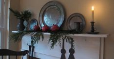 a mantel with candles and plates on it