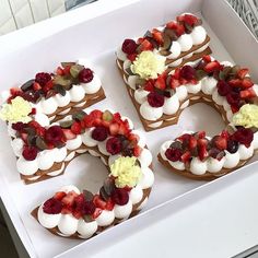 the number 50 is decorated with strawberries and other toppings in a white box