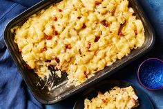 a pan filled with macaroni and cheese sitting on top of a blue cloth