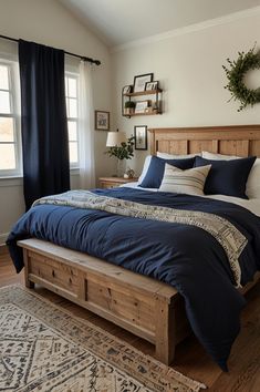 a bed with blue sheets and pillows in a bedroom next to a rug on the floor