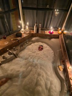 a bathtub filled with lots of white foam and candles