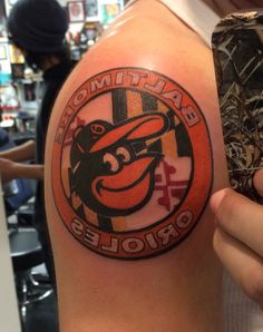 a man with a baltimore orioles tattoo on his arm