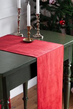 a table with two candles on it next to a christmas tree