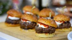 mini burgers with meat and cheese on a cutting board