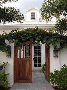 an entrance to a white house with wooden doors