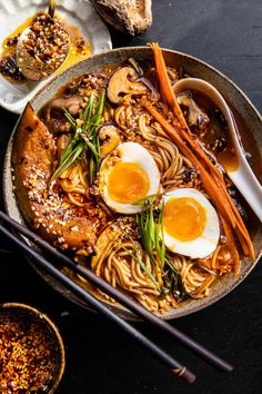 a white bowl filled with noodles, meat and an egg