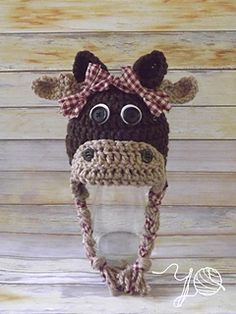 a crocheted cow with big eyes and a bow on it's head