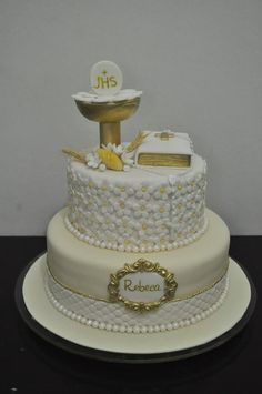 a three tiered cake with white frosting and gold decorations