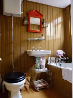 a bathroom with a toilet, sink and mirror