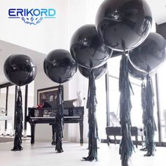 black balloons with tassels in front of a piano