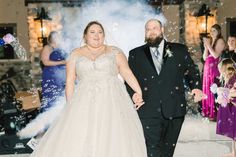 a bride and groom are walking through bubbles at their wedding reception in front of guests