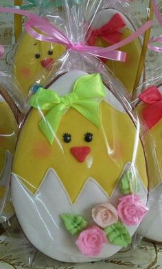 four decorated eggs in plastic bags with bows on them