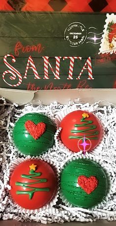 three green and red christmas ornaments in a box with santa's tree on them