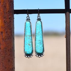 Antique silver plated elongated teardrop around turquoise natural stone earrings in turquoise. Drop: 2" Southwestern Turquoise Teardrop Earrings, Southwestern Style Teardrop Dangle Earrings, Turquoise Nickel-free Southwestern Teardrop Earrings, Southwestern Nickel-free Teardrop Earrings, Natural Stone Earrings, Turquoise Earrings, Stone Earrings, Natural Stone, Antique Silver