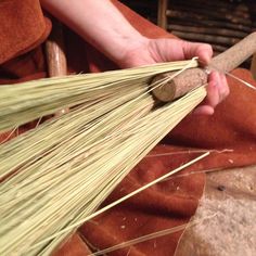 a person is using a wooden stick to cut grass