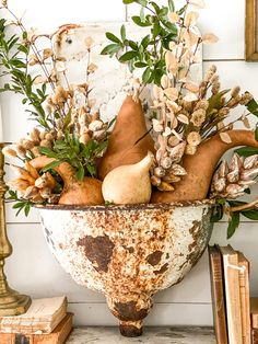 a large metal bowl filled with lots of different types of flowers and plants on top of a table