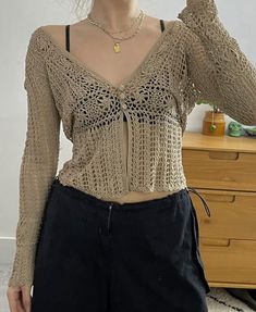 a woman is taking a selfie with her cell phone while wearing a crochet top