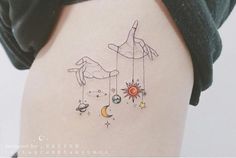 the back of a woman's stomach with an image of two hands and planets hanging from strings