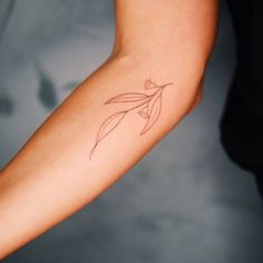 a woman's arm with a flower tattoo on the left side of her arm