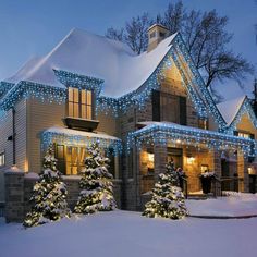 a house covered in christmas lights and snow