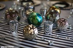 there are many different colored glass balls on the table