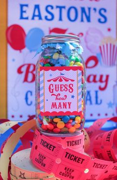 a glass jar filled with candy next to a ticket