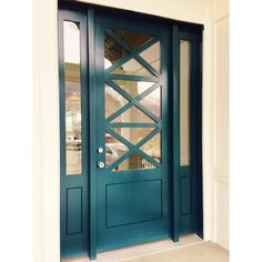 the front door is painted teal and has glass panels on each side, along with an arched window