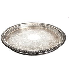 a silver tray with beading on the rim and handles is shown against a white background