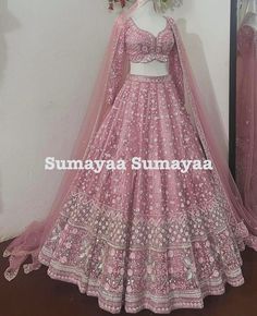 a pink lehenga is displayed on a mannequin in front of a mirror