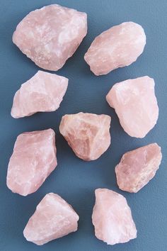 several pink rocks are arranged on a blue surface