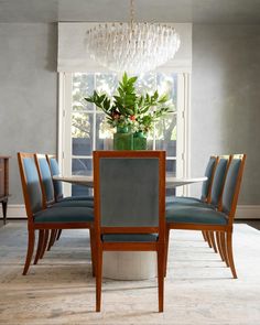 a dining room table with blue chairs and a chandelier