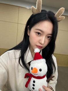 a woman holding a snowman stuffed animal