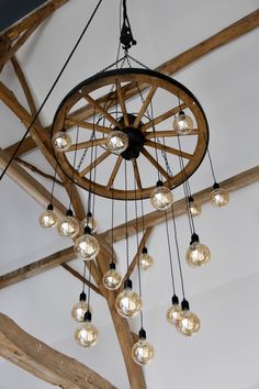 a chandelier hanging from the ceiling in a room with wooden beams and lights