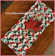 a crocheted table runner with a red bird on it